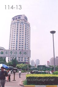 Foto 114-13 - Estacionamiento de los Autobuses que viajan de Shanghai a Zhouzhuang, al fondo la torre Flantra en Shanghai China - 11-Junio-2006