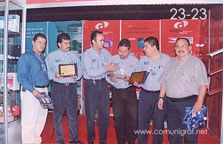 Foto 23-23 - En el stand de Allegro Pre-prensa digital, sus representantes recibiendo sus reconocimientos de participación de parte de Don Raúl Erbez Cortéz (Q.E.P.D.) (derecha) en la Expo Artes Gráficas León 2003 en el Poliforum de la ciudad de León, Gto. México.