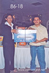 Foto 86-18 - Feliz afortunado con un reproductor de DVD, lo entrega Delia Hernández (izq) en la tradicional Comida Baile del día del Impresor de Canagraf Guanajuato, realizada el 24 de Septiembre 2005 en el Hotel La Nueva Estancia de la Ciudad de León, Guanajuato México.