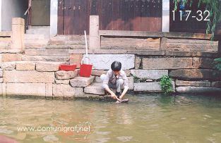 Foto 117-32 - Persona del lugar, lavando un zapato en uno de los canales de agua del pueblo viejo de Zhouzhuang, China - 11-Junio-2006