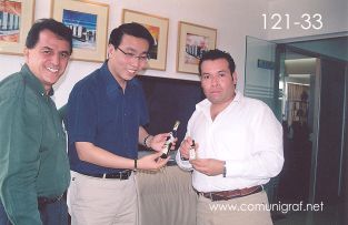Foto 121-33 -  Javier Navarro (izq) y Humberto Mata (der) obsequiando una pequeña botella de tequila a Frank Li (centro) de la empresa Guanghua Printing Machinery en Shanghai China - 12-Junio-2006