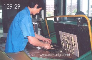 Foto 129-29 - Limpiando el área de registro de la máquina de suajado en la nave de impresión offset de la empresa Shanghai Xinya Printing Co Ltd de Wenzhou, Shanghai China - 13-Junio-2006