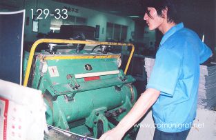 Foto 129-33 - Empleado en la máquina de suajado en la nave de impresión offset de la empresa Shanghai Xinya Printing Co Ltd de Wenzhou, Shanghai China - 13-Junio-2006