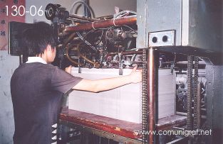 Foto 130-06 - Empleado metiendole papel a una máquina de impresión offset en la nave de impresión offset de la empresa Shanghai Xinya Printing Co Ltd de Wenzhou, Shanghai China - 13-Junio-2006