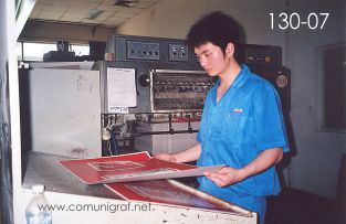 Foto 130-07 - Prensista revisando las primeras impresiones antes de continuar con el tiro completo en la nave de impresión offset de la empresa Shanghai Xinya Printing Co Ltd de Wenzhou, Shanghai China - 13-Junio-2006