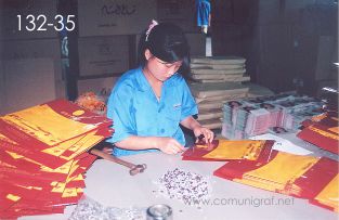 Foto 132-35 - Señorita ojillando bolsas para regalo en la planta de Shanghai Xinya Printing Co Ltd de Wenzhou, Shanghai China - 13-Junio-2006