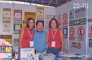 Foto 22-10 - En el stand de la Revista Comunigraf: Chayo y Diana alumnas del ICAGG con José Regino Torres V. en la Expo Artes Gráficas León 2003 en el Poliforum de la ciudad de León, Gto. México.